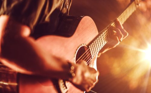 Acoustic Guitar Playing. Men Playing Acoustic Guitar Closeup Photography.